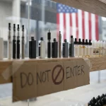 Rayonnage de cigarettes électroniques dans un commerce américain avec signalétique d'interdiction, illustrant la nouvelle loi de l'Indiana sur les vapes étrangères